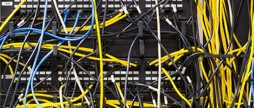 Hundreds of Tangled Network Cables on a Computer Network
